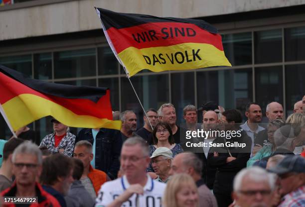 Supporters of the far-right "Zukunft Heimat" movement hold up German flags, including one that reads: "We are the people," at a gathering on German...