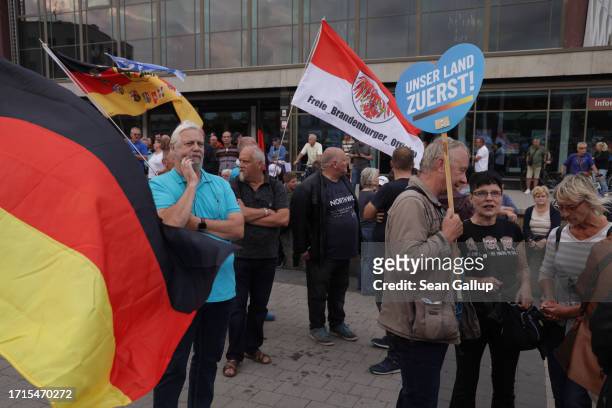 Supporters of the far-right "Zukunft Heimat" movement, including one man with a sign that reads: "Our country first!", gather with German flags on...