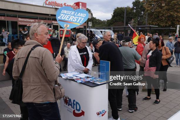 Supporters of the far-right "Zukunft Heimat" movement gather as a volunteer with the far-right Alternative for Germany political party distributes...