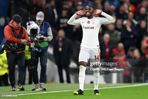 Wilfried Zaha of Galatasaray S.k celebrates after scoring the team's first goal during the UEFA Champions League match between Manchester United and...