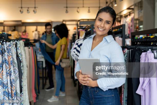 happy business owner smiling at a clothing store - portrait department store stockfoto's en -beelden