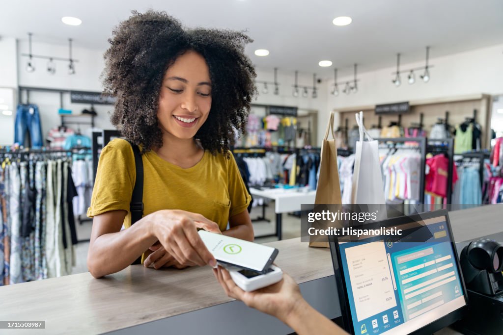 Woman making a mobile payment at a clothing store