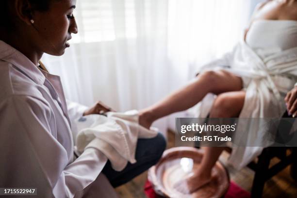 therapist drying a client feet at a spa - foot bath stock pictures, royalty-free photos & images