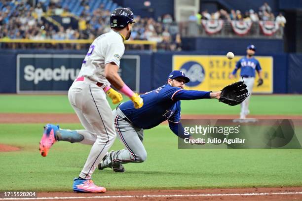 Jordan Montgomery of the Texas Rangers dives to make a catch on an attempted bunt by Jose Siri of the Tampa Bay Rays in the second inning during Game...