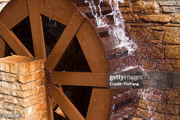 water wheel or watermill turbine grinding, turning, and generating power - watermolen stockfoto's en -beelden