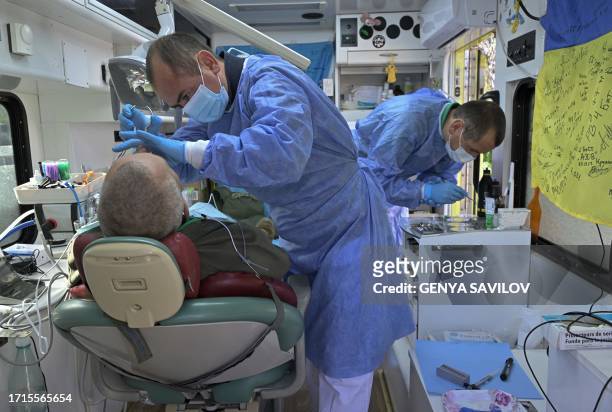 Dentists treat a Ukrainian serviceman in a mobile dental clinic in the town of Kramatorsk, Donetsk region, on October 7 amid the Russian invasion of...