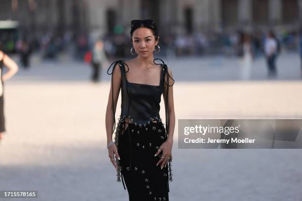 Yoyo Cao is seen outside Mugler show wearing silver hoop earrings, black leather tank top, black long skirt with silver details during the Womenswear...