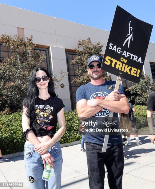 Krysten Ritter and Skeet Ulrich join the picket line outside Warner Bros. Studios on October 03, 2023 in Burbank, California. The WGA has reached a...