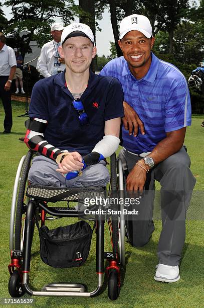 Wounded Warrior Brendan Marrocco and Tiger Woods pose for a photo on the first tee during the patriotic opening ceremony for the AT&T National at...