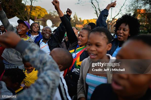 People gather and sing as they leave messages of support for former South African President Nelson Mandela outside the Mediclinic Heart Hospital June...