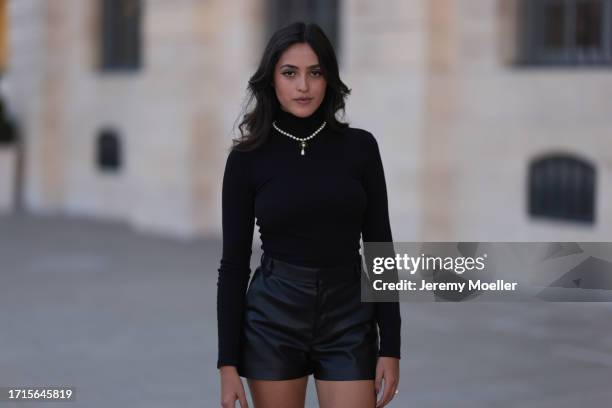 Agustina Walker Castro-Rioseco is seen wearing pearl earrings and a pearl necklace with golden pendant from Vivienne Westwood; a black, long-sleeved,...