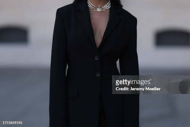 Agustina Walker Castro-Rioseco is seen wearing a three-row pearl necklace with a golden pendant covered with rhinestones from Vivienne Westwood and a...