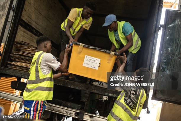 National Elections Commission agents load trucks with election material in Monrovia on October 09, 2023. Outgoing president George Weah, a legend of...