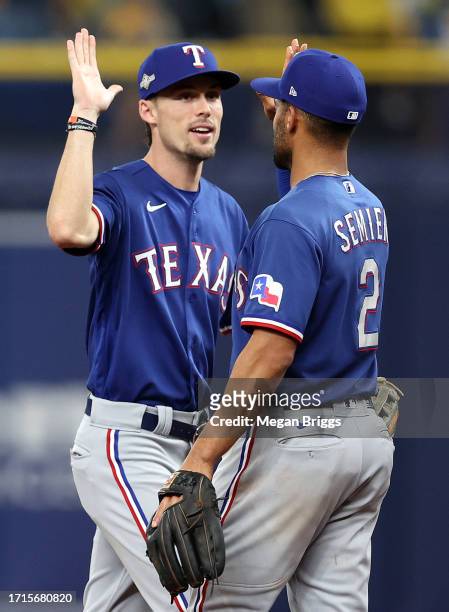Marcus Semien celebrates with Evan Carter of the Texas Rangers after defeating the Tampa Bay Rays 4-0 in Game One of the Wild Card Series at...
