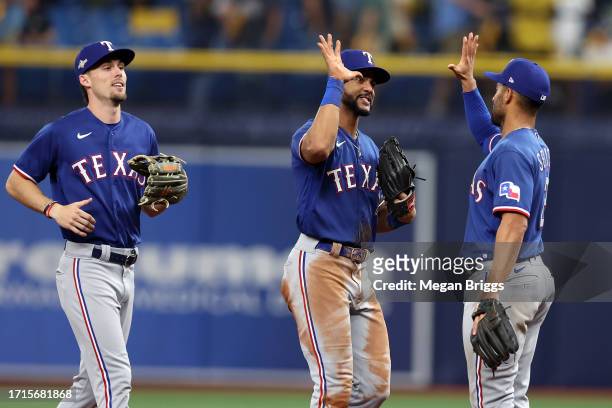 Marcus Semien celebrates with Leody Taveras of the Texas Rangers after defeating the Tampa Bay Rays 4-0 in Game One of the Wild Card Series at...
