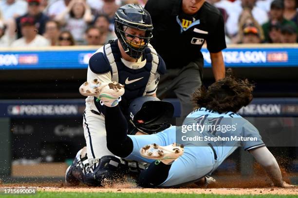Ryan Jeffers of the Minnesota Twins tags out Bo Bichette of the Toronto Blue Jays at home plate during the fourth inning in Game One of the Wild Card...