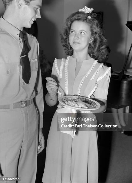 Actress Shirley Temple chats with future husband John Agar in 1944 in Los Angeles, California.