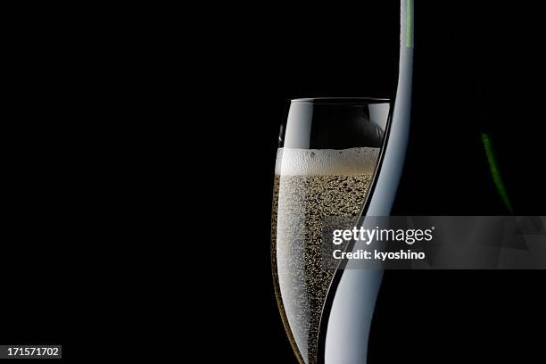 champagner, glas und leere flasche vor schwarzem hintergrund - champagne coloured stock-fotos und bilder