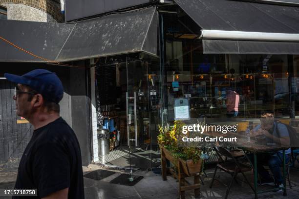 Man stands outside a Jewish-owned restaurant that had a glass door smashed in overnight, on October 9, 2023 in the Golders Green area of London,...