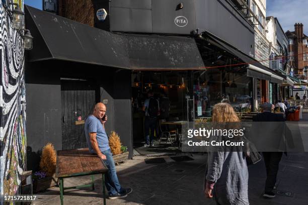 People pass a Jewish-owned restaurant that had a glass door smashed in overnight, on October 9, 2023 in the Golders Green area of London, England....