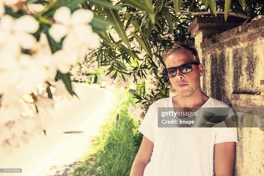 Handsome man under a oleander