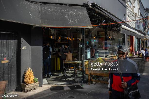 Man passes a Jewish-owned restaurant that had a glass door smashed in overnight, on October 9, 2023 in the Golders Green area of London, England. The...