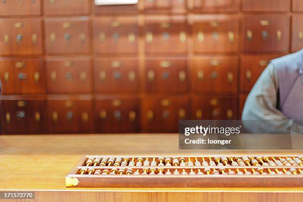 traditional chinese medicine shop - gold abacus stock pictures, royalty-free photos & images