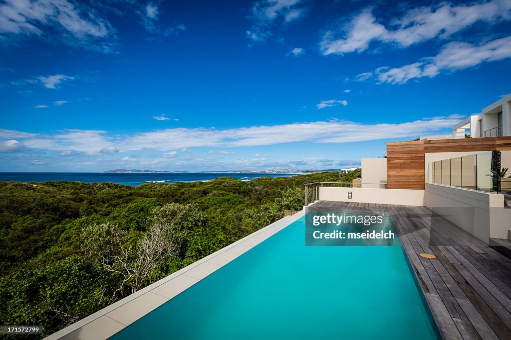Large luxury villa pool and deck on a cliff with ocean view