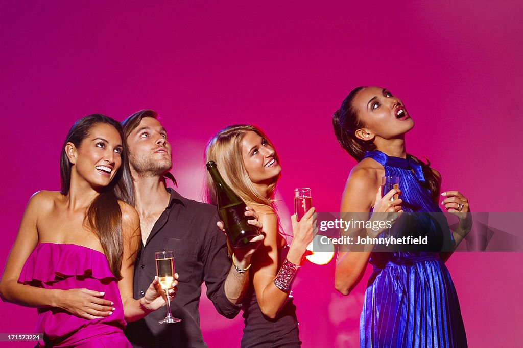 Friends With Drinks Looking Up At Nightclub