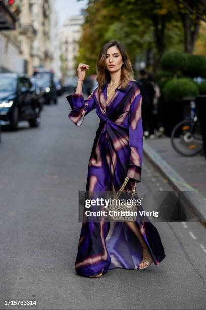 Maria Kokhia wears purple not printed maxi dress by Maria Kokhia, beige Chanel bag, heels during the Womenswear Spring/Summer 2024 as part of Paris...