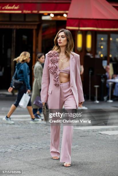 Maria Kokhia wears pink flower blazer, straight-leg pants by Maria Kokhia, bag, sandals during the Womenswear Spring/Summer 2024 as part of Paris...