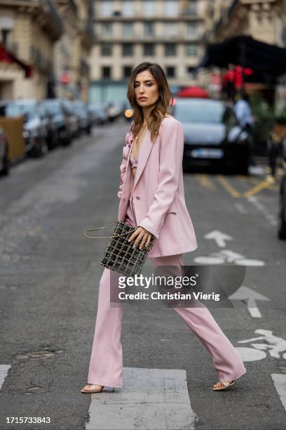 Maria Kokhia wears pink flower blazer, straight-leg pants by Maria Kokhia, bag, sandals during the Womenswear Spring/Summer 2024 as part of Paris...
