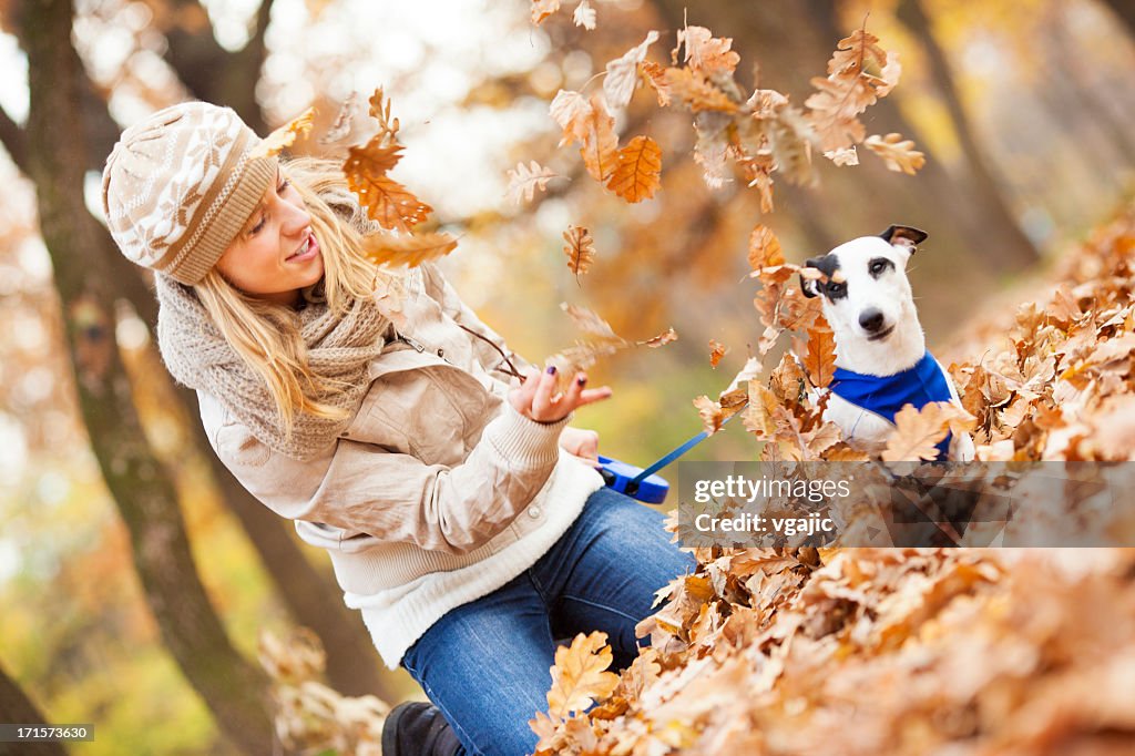 Happy Young Woman Playing With her dog outdoors.