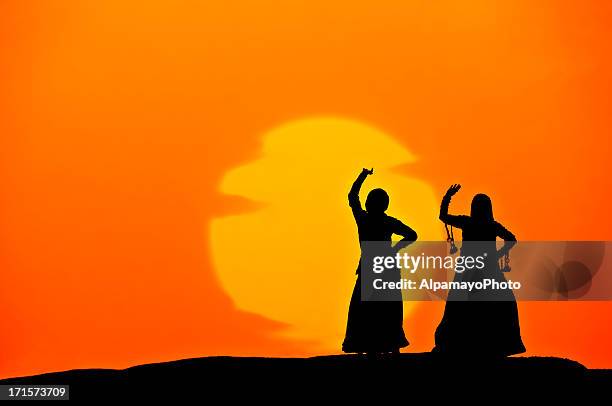 silhouette of indian women dancing on sand dunes (sunset) (xv) - dancer india stockfoto's en -beelden