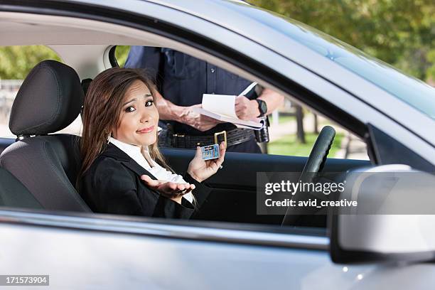 female driver receiving citation from police - female disciplinarians stock pictures, royalty-free photos & images