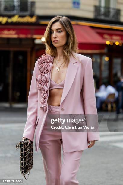 Maria Kokhia wears pink flower blazer, straight-leg pants by Maria Kokhia, bag during the Womenswear Spring/Summer 2024 as part of Paris Fashion Week...