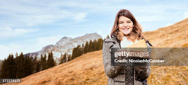 schöne frau präsentieren-käse in schweizer alpen berge - schweizer käse stock-fotos und bilder