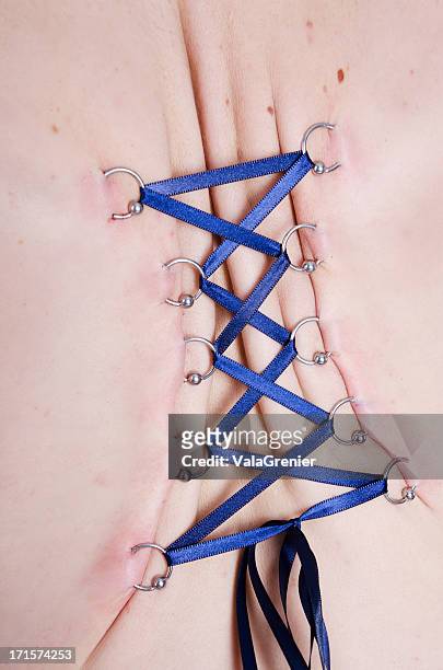 closeup of tightly cinched corset piercing. - body piercings stock pictures, royalty-free photos & images