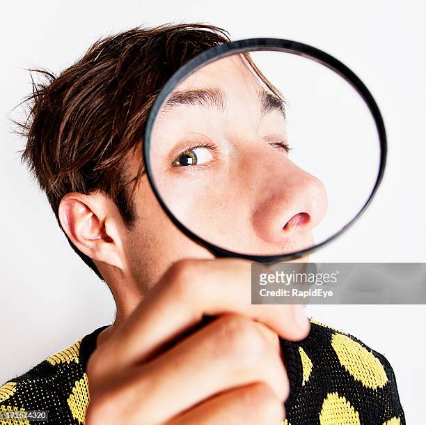 bizarre boy examining face through magnifying glass - big nose 個照片及圖片檔