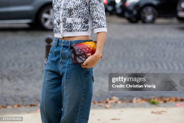 Xenia Adonts wears denim jeans, black white button up jacket, brown red yellow bag outside Chanel during the Womenswear Spring/Summer 2024 as part of...