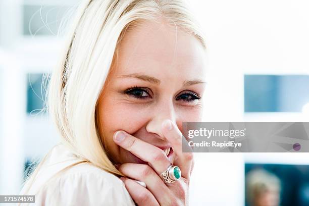 schöne junge blonde frau lacht in die hand - ring schmuck stock-fotos und bilder
