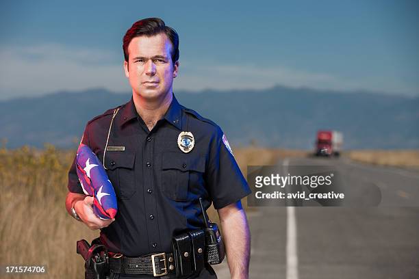 police officer on roadway with flag - police respect stock pictures, royalty-free photos & images