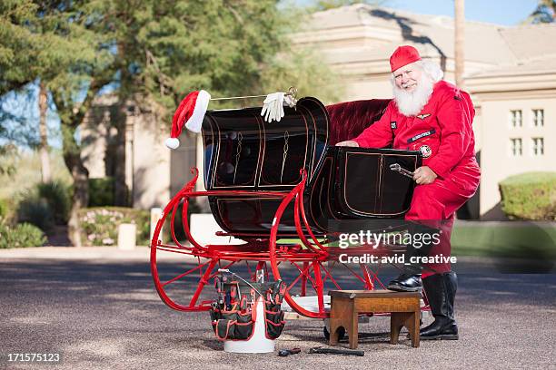 real santa mechanic working on sleigh - sleigh stock pictures, royalty-free photos & images