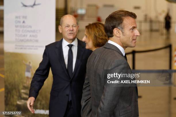 German Chancellor Olaf Scholz and his partner Britta Ernst greet French President Emmanuel Macron as he arrives at the Airbus plant in Hamburg,...