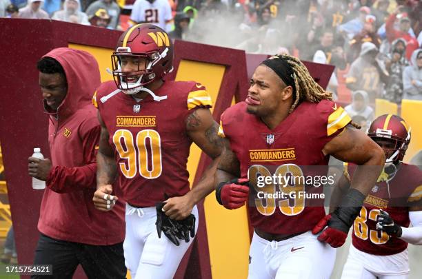 Montez Sweat and Chase Young of the Washington Commanders run onto the field before the game against the Buffalo Bills at FedExField on September 24,...