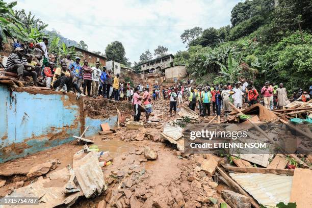 Residents look at the destruction caused by a landslide in the district of Mbankolo, northwest of Yaounde, on October 9, 2023. At least 27 people...