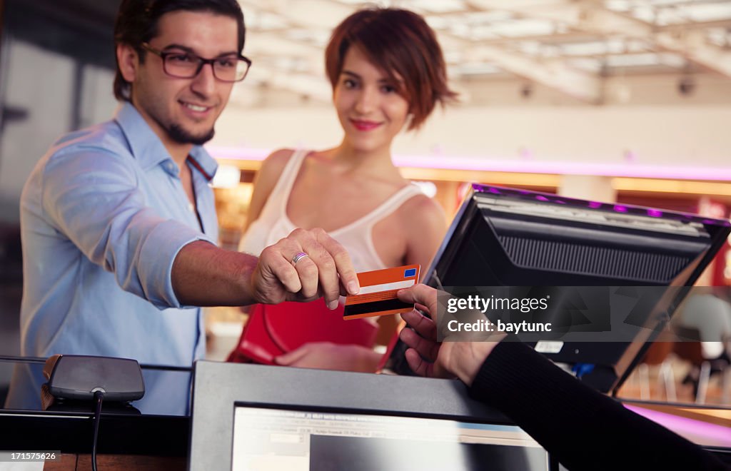 Feliz pareja ENTRADAS PARA IR AL CINE de pagar con tarjeta de crédito