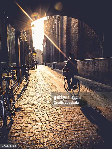 woman cycling at sunrise in ferrara, italy - ferrara stock pictures, royalty-free photos & images