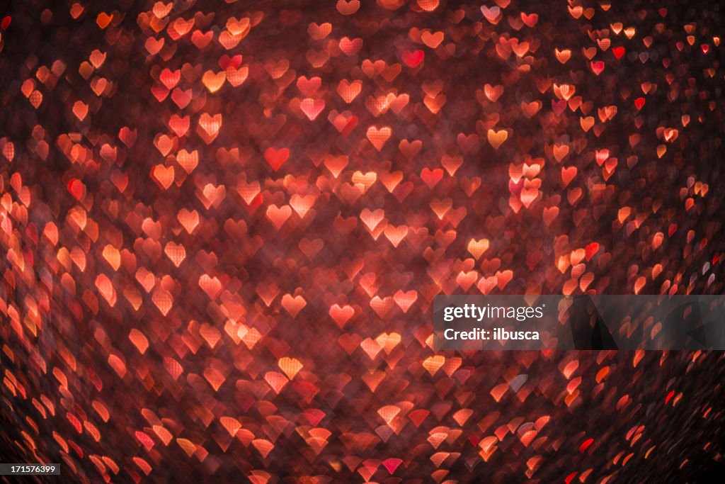 En forma de corazón abstracto bokeh defocussed fondo de Navidad rojo luz