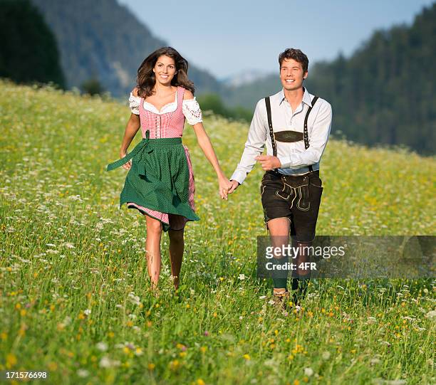 couple in traditional tracht running through the meadows (xxxl) - läderbyxor bildbanksfoton och bilder